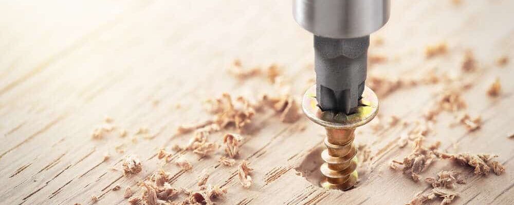welcher dübel hält wo? die 8 häufigsten untergründe im überblick 23 nahaufnahme einer holzschraube, die mit einem schraubendreher in ein holzstück gedreht wird.