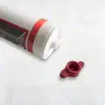 Verschlusskappe für Silikon, rot, neben einer Silikonkartusche mit grafischem Design.