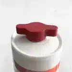 Rote Verschlusskappe für Silikon-, Acryl- & Montagekleber, die auf einem weißen Behälter sitzt.